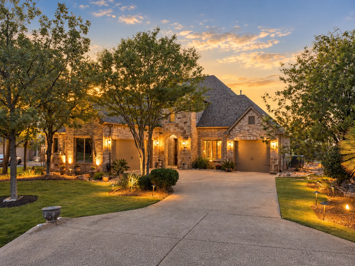 Stone and brick home with landscape lighting in The Resort on Eagle Mountain Lake